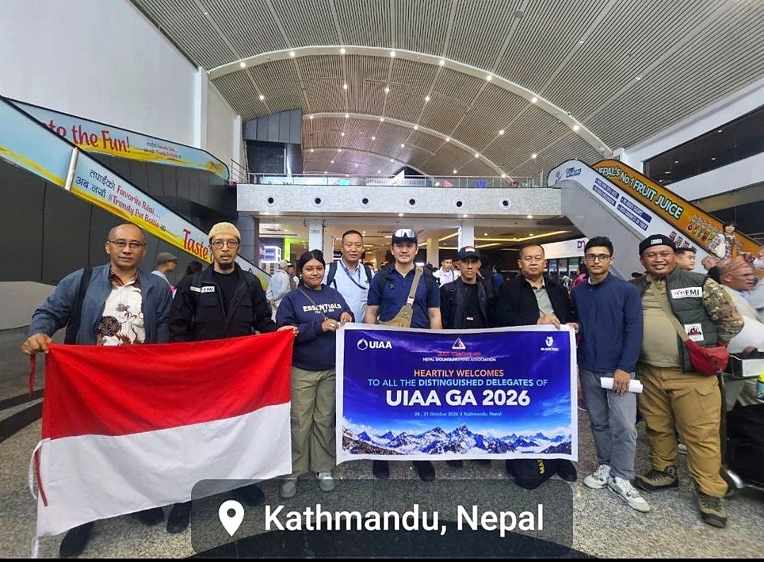 Rombongan delegasi FMI berfoto memegang bendera Merah Putih dan spanduk sambutan UIAA GA 2026 di aula kedatangan Bandara Internasional Tribhuvan, Kathmandu