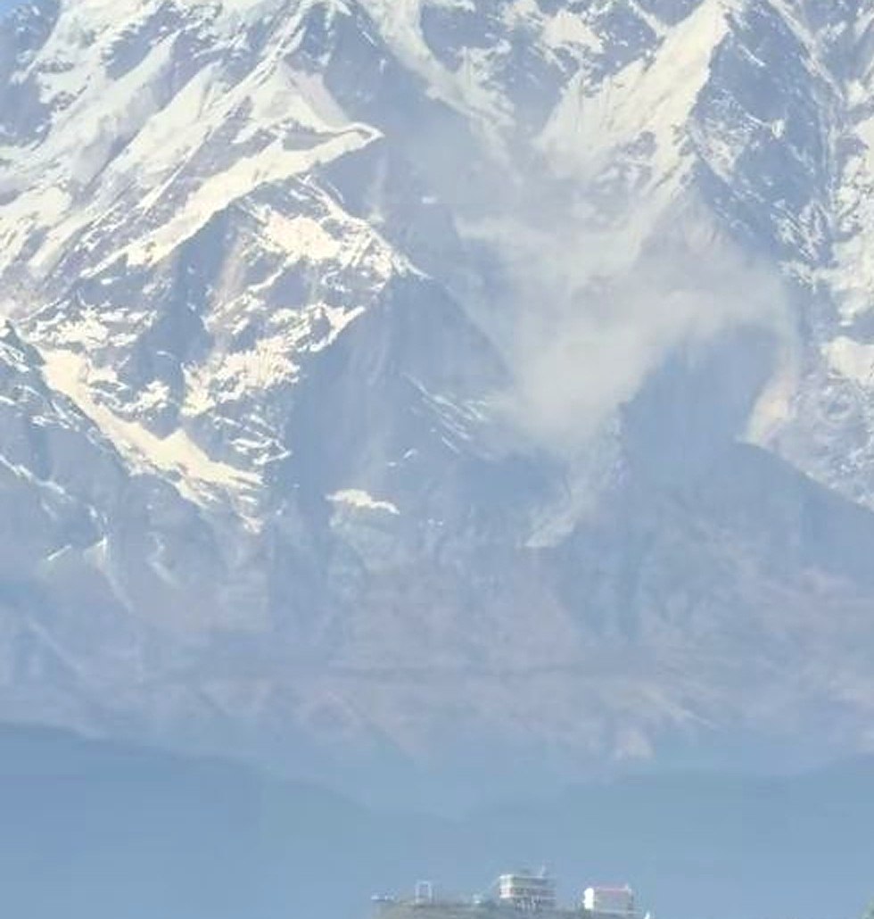Dinding pegunungan bersalju Annapurna dengan kabut tebal dan longsoran salju, dilihat dari perbukitan dekat Pokhara
