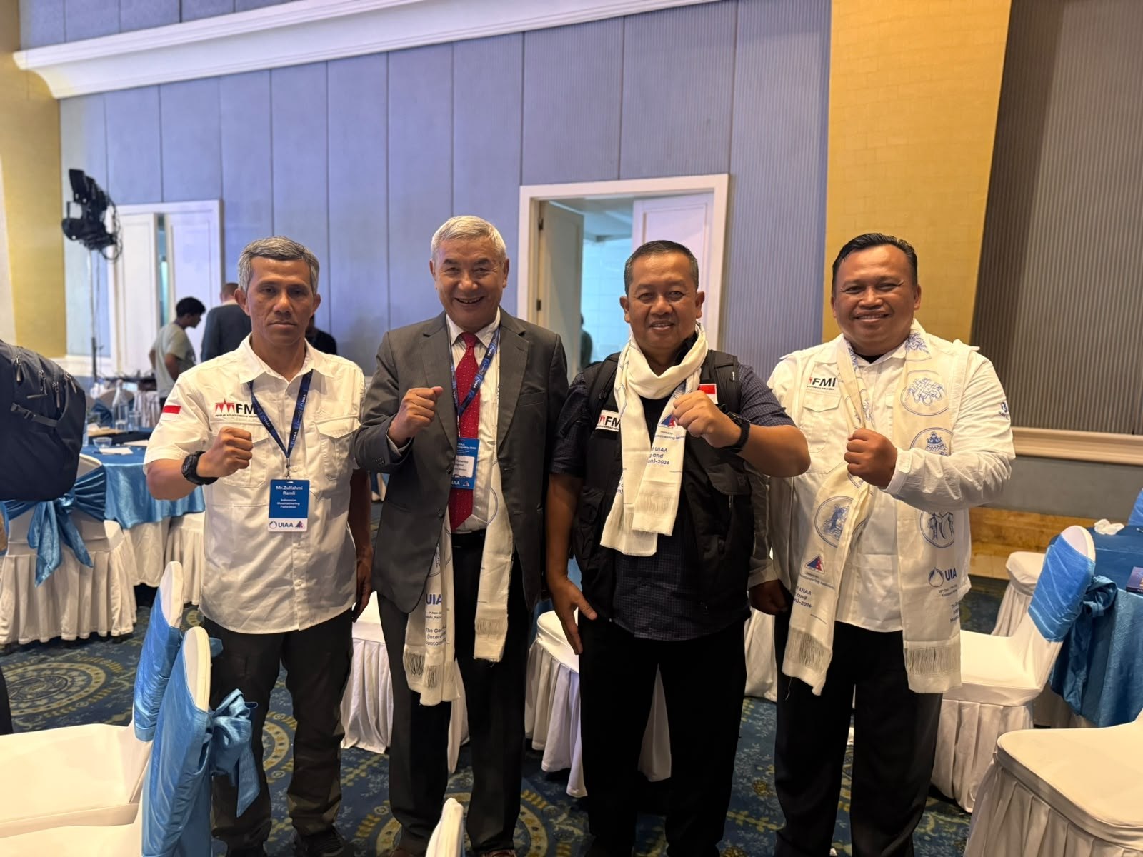 Peserta pembukaan Sidang Umum UIAA 2026 berfoto bersama di ruang acara sambil mengenakan selempang putih bertuliskan UIAA General Assembly 2026